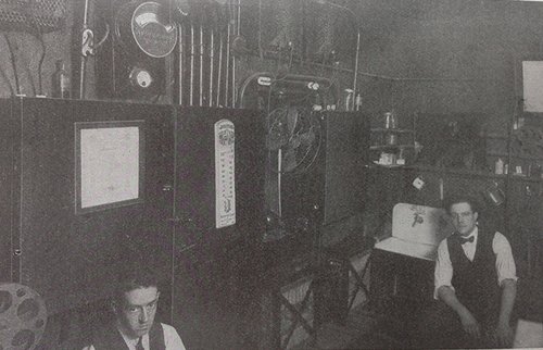 Two men sitting in the Monarch Theatre projection room, in Cleveland, Ohio.