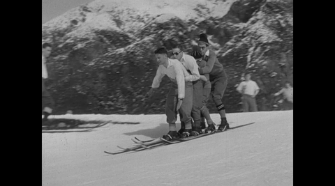 Four people sharing a set of skis