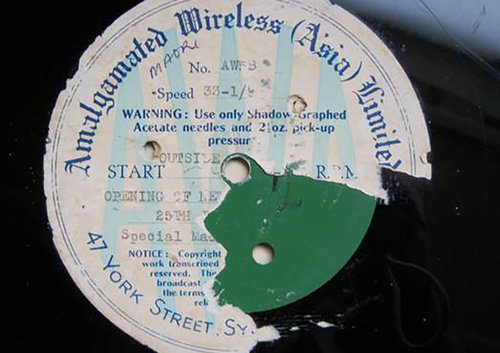 A battered record label, one half has been peeled away. The title of the record says ' Amalgamated Wireless (Asia) Limited'