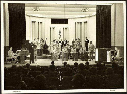 A big band onstage with a man at a microphone