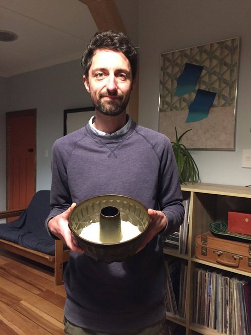A man holding a baking pan with mystery contents