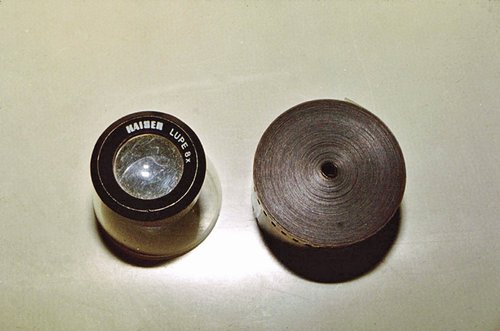 Old film reel and magnifying tool.