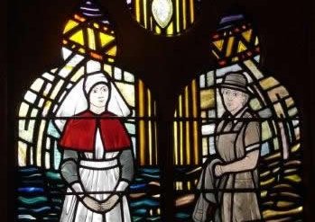 A stained glass window depicting two nurses