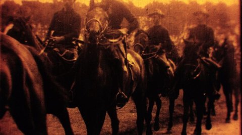 A film still from The Departure of the Second Contingent for the Boer War. A group of soldiers are riding horses.