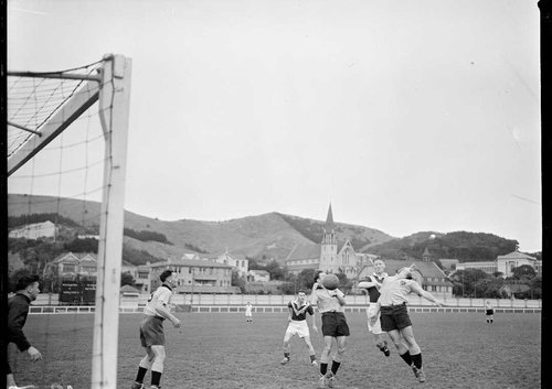 Men playing football. St Mark’s Church and Wellington College are in the background.