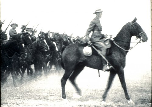 A soldier on horseback leads a number of other soldiers on horseback.