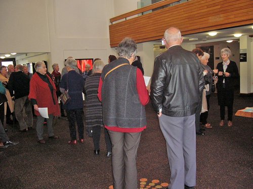Audience members are waiting in the foyer to see the film.