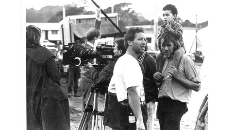 Crew members and child behind the scenes on film set.