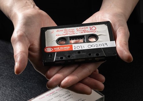 Close-up of hands holding a cassette tape from the collection