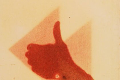 Still from Len Lye footage depicting a thumbs up.