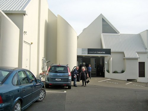 The outside of the MTG Theatre in Napier. An older couple are getting out of their car in front of the building.