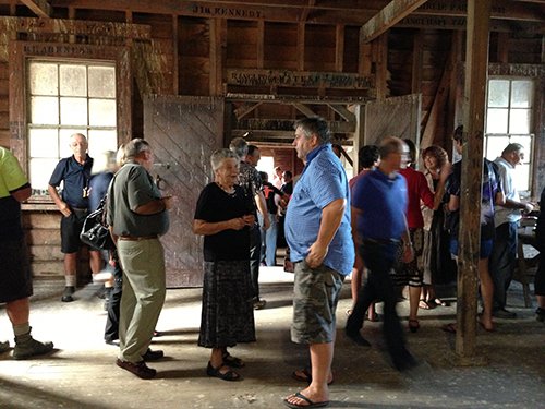 A crowd of people are gathered inside the woolshed.