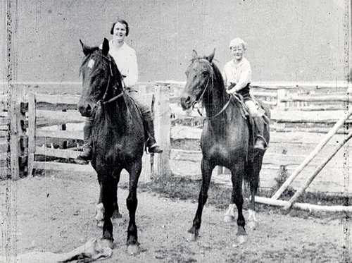 Woman and boy on horseback.