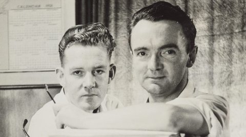 Image of Mike Walker and Bob Morrow, from Morrow Productions, standing behind a large pile of papers.