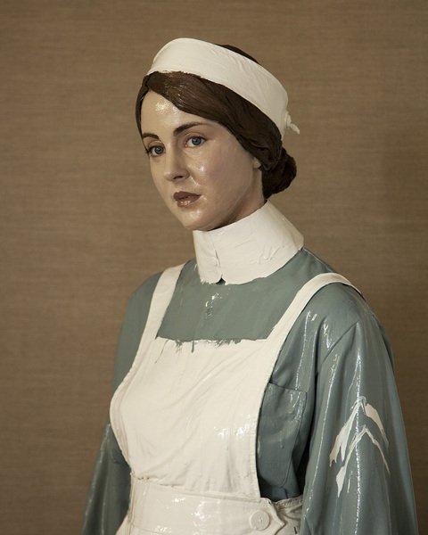 A ceramic figure of a nurse wearing a hat and apron.