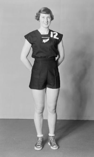 A young woman wears a New Zealand athletics uniform