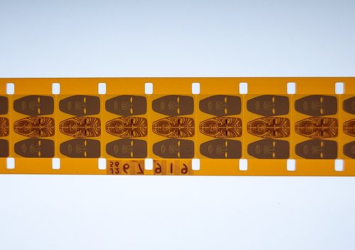 A strip of film from Tangata Whenua on a lighted workbench.