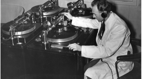 Basil Clarke records an incoming broadcast while on 'listening watch' in the control room of station 2YA in Wellington, during WWII.