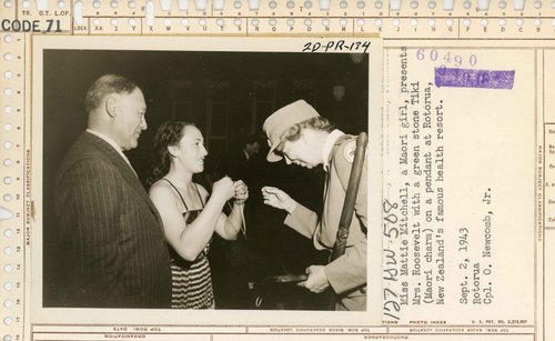 A young Māori girl presents a pounamu (green stone Tiki) to Eleanor Roosevelt.