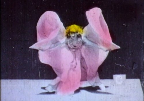 A still from the film The Serpentine Dance depicts a dancer with blond hair and a pink dress.