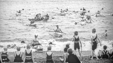 Photo of people on the beach and kayaking in the water.