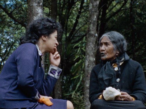 Two Maori women talking in a wooded area