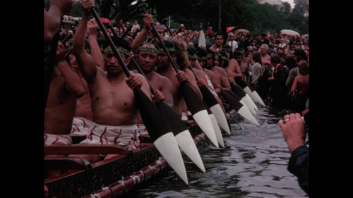 Still from a film by Tauranga amateur filmmaker Norman Blackie - Crowd of people watching a waka being launched.