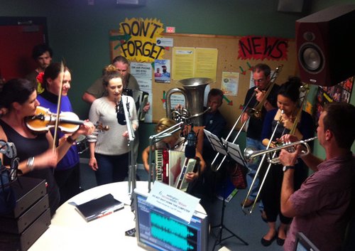 Musicians playing in a small studio.