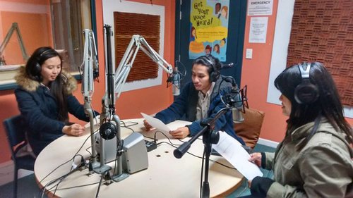 Three people in radio broadcasting studio.