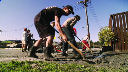 Members of the Student Volunteer Army helping to shovel away liquefaction in Halswell, Christchurch.