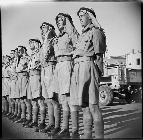 A row of men in Arab style headdresses and knee socks