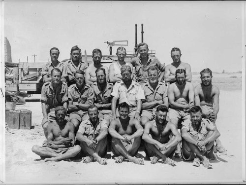 A group of soldiers posing by a truck