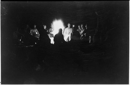 Night-time shot of men sitting around a campfire