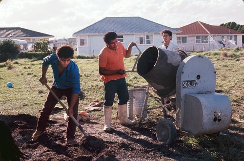 Group of three Pacific Island men mixing cement outside a house