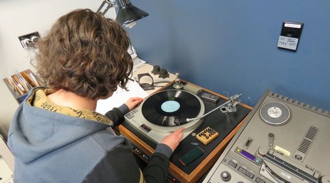 A staff member places an old record on a player.