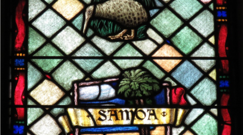 A stained glass window window depicting a kiwi and a tree with the word 'Samoa' in front of it.