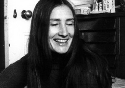 A woman in a turtleneck with long hair and a smile.